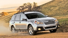 Серебристый Subaru Outback поднимает столбы пыли